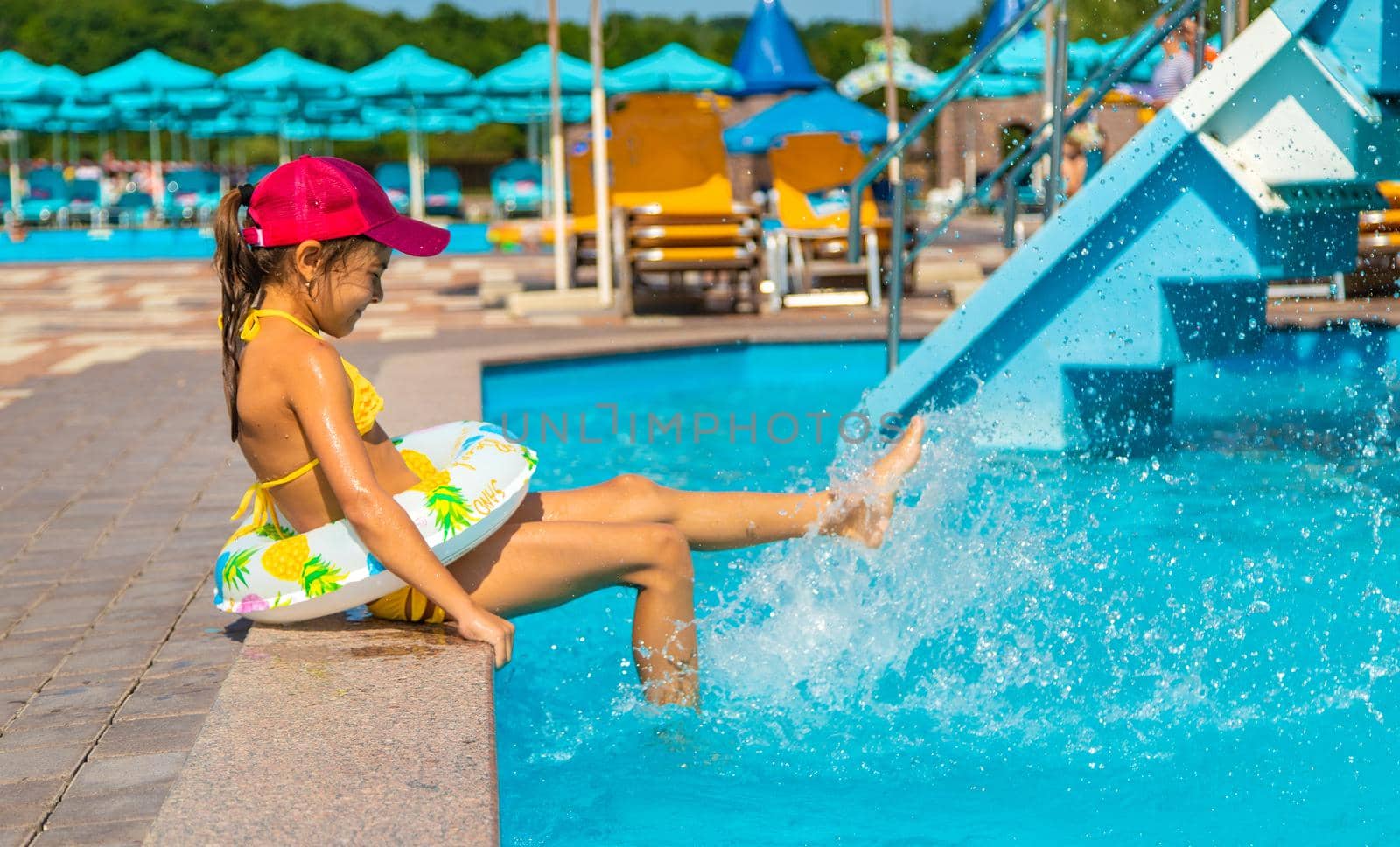 The child swims in the pool in a circle. Selective focus. Kid.