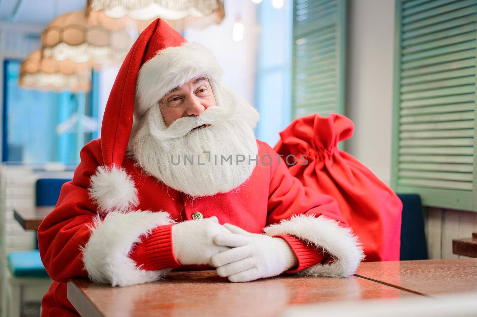 Friendly santa claus in a cafe. by mrwed54