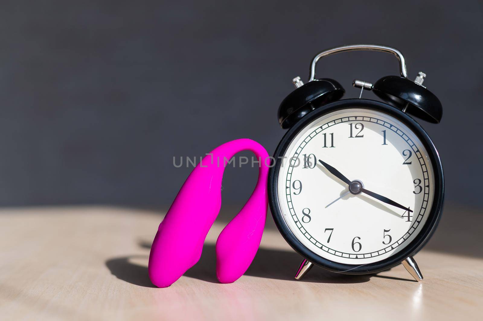 Time for carnal pleasures. Alarm clock and stimulator G spot. Pink vibrator for masturbation