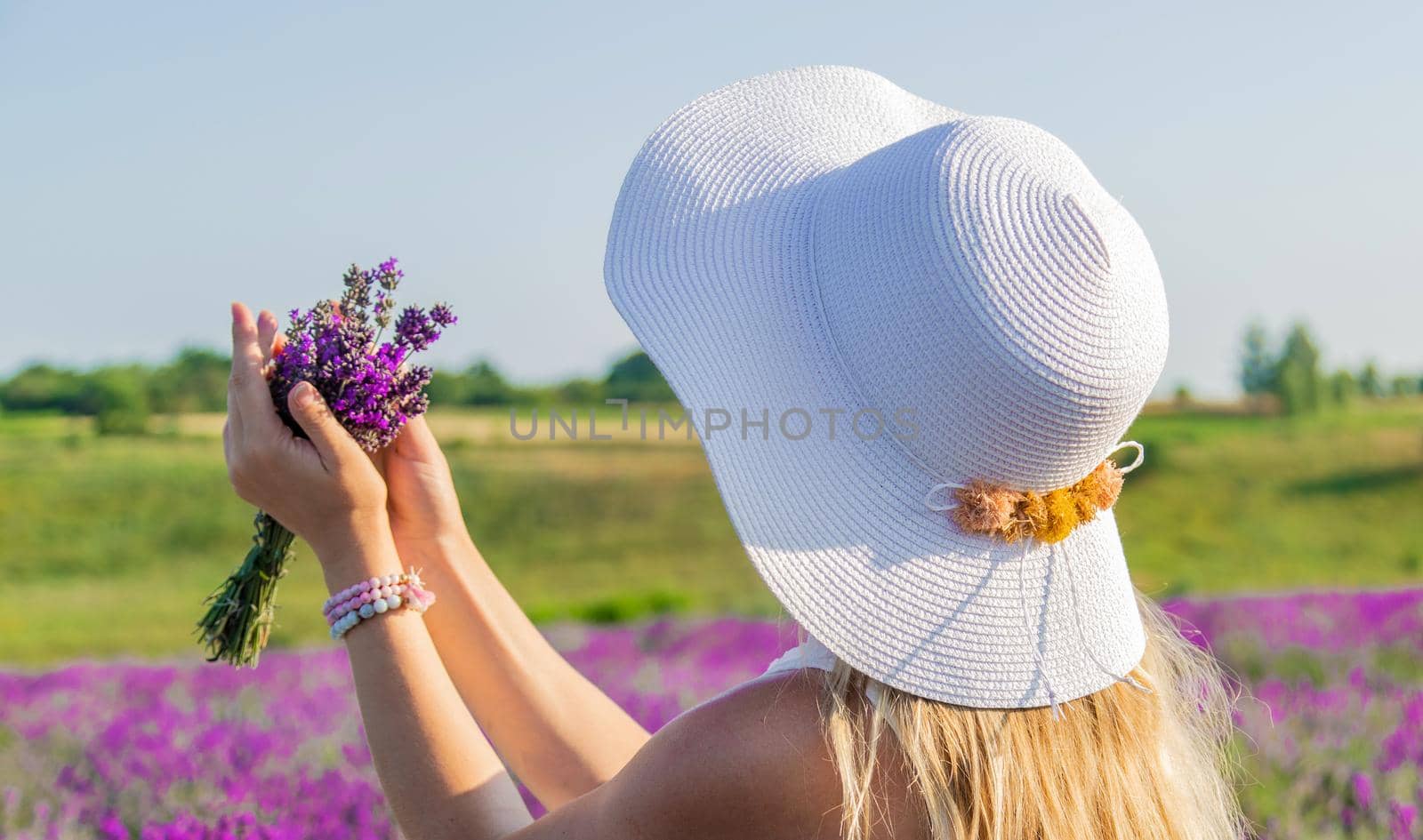 Woman with hat in lavender field. Selective focus. Nature.