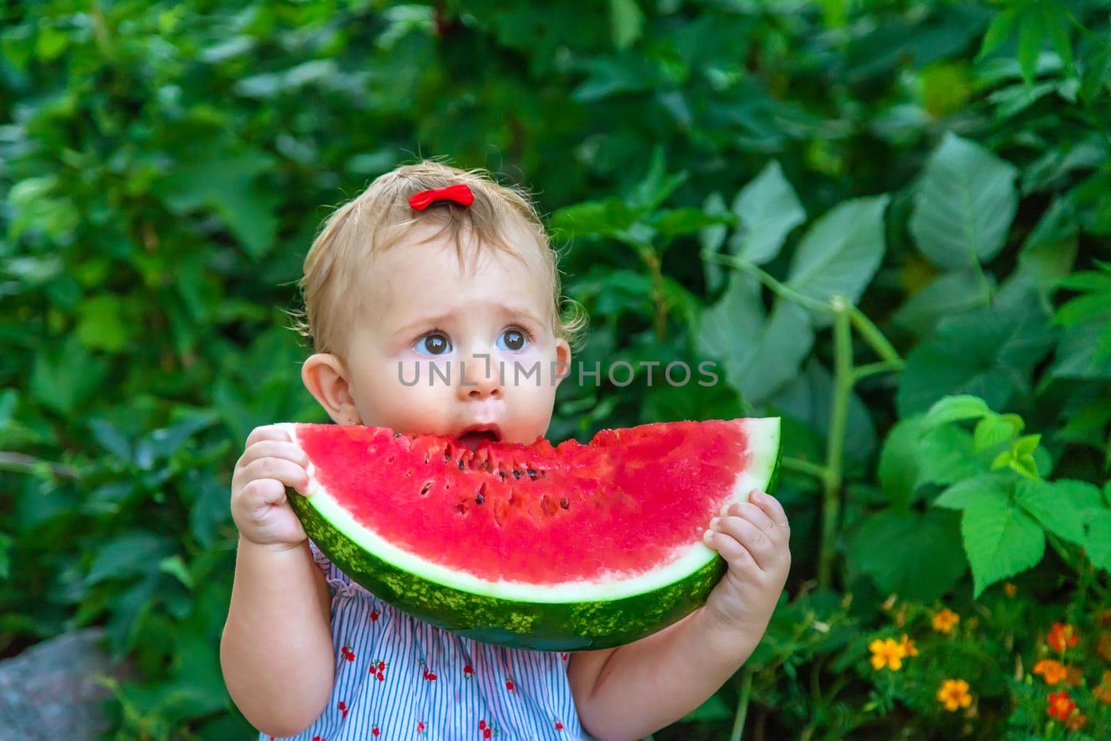 Baby eats watermelon in summer. Selective focus. Food.