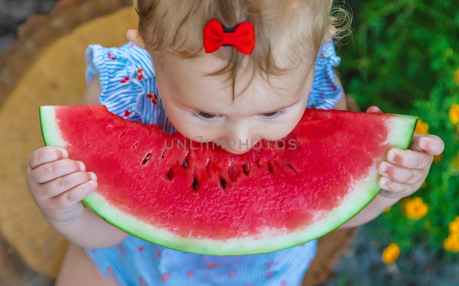 Baby eats watermelon in summer. Selective focus. Food.