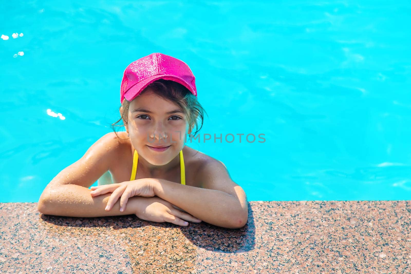 The child is swimming in the pool. Selective focus. Kid.