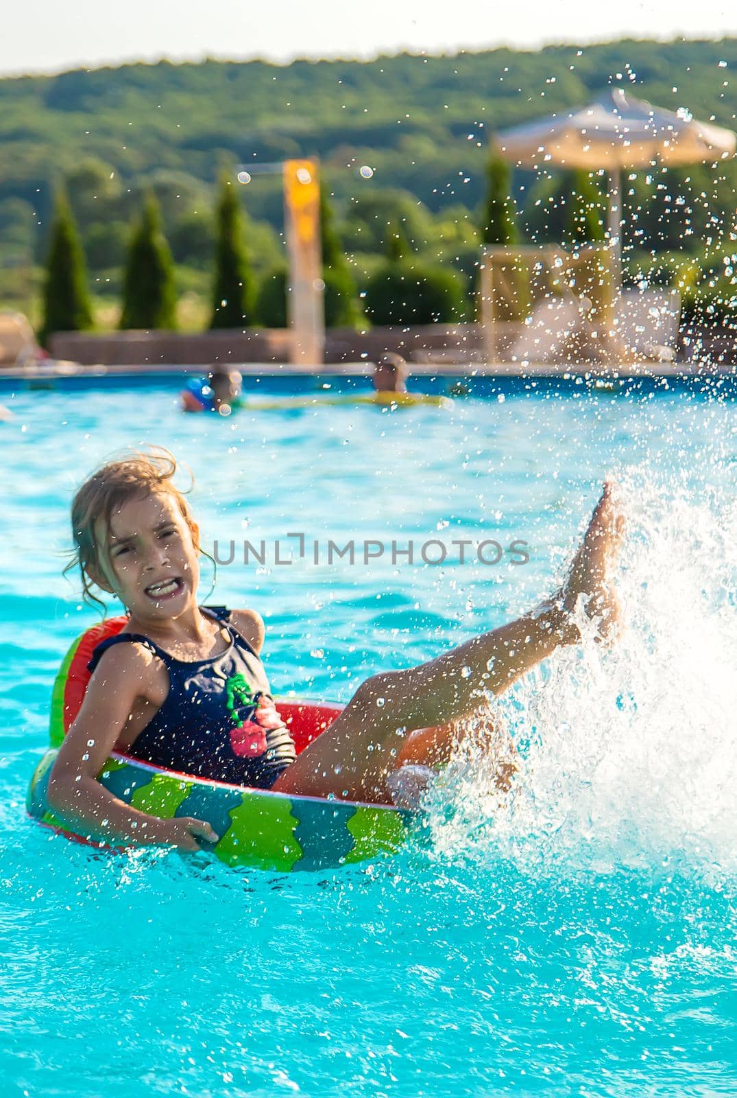 A child in a circle swims in the pool. Selective focus. Kid.