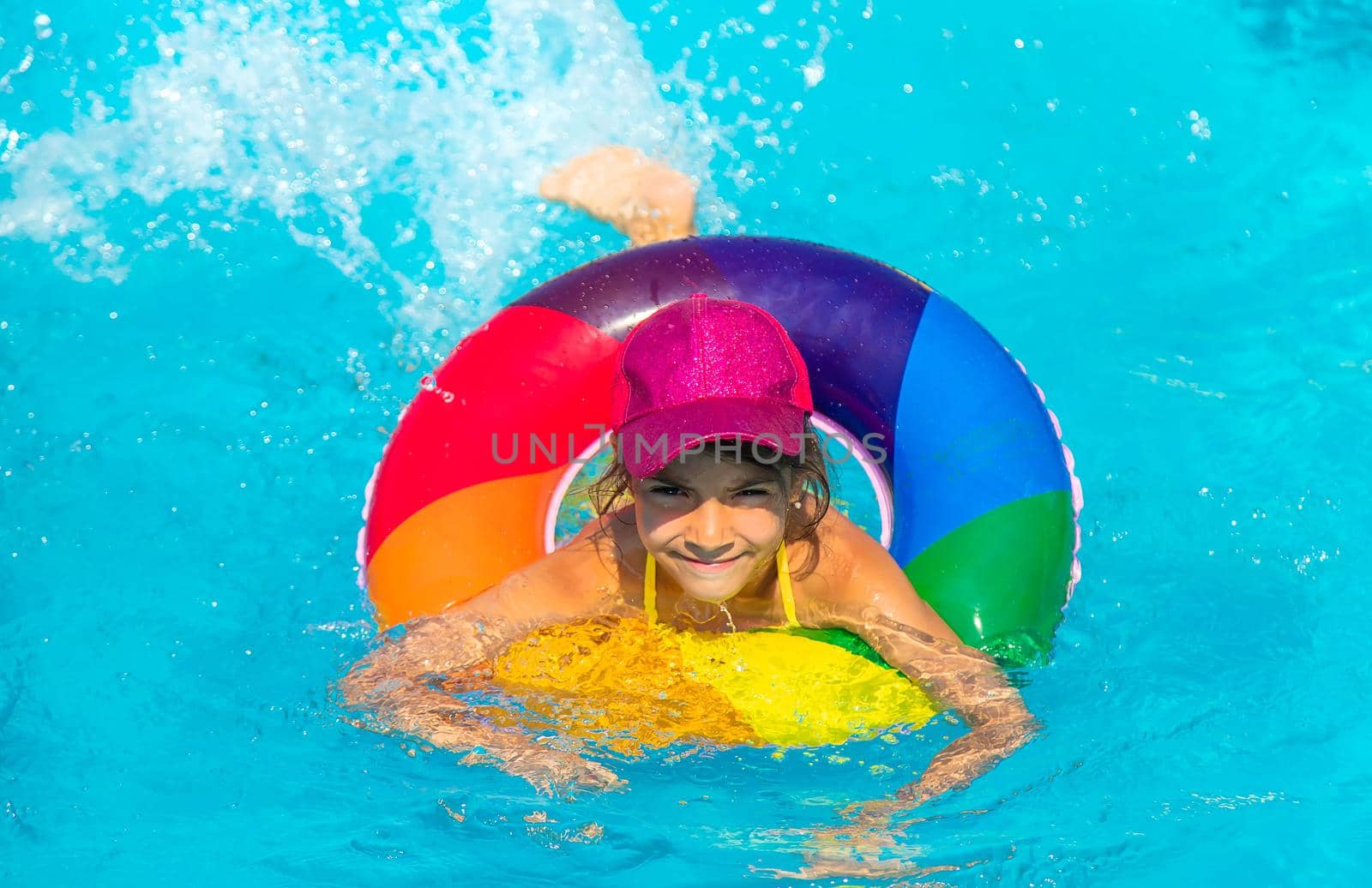 The child swims in the pool in a circle. Selective focus. Kid.
