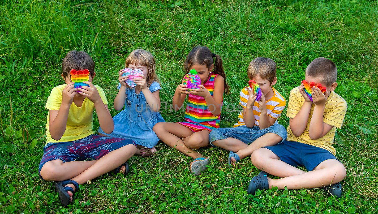 Children play anti-stress popit on the street. Selective focus. by yanadjana