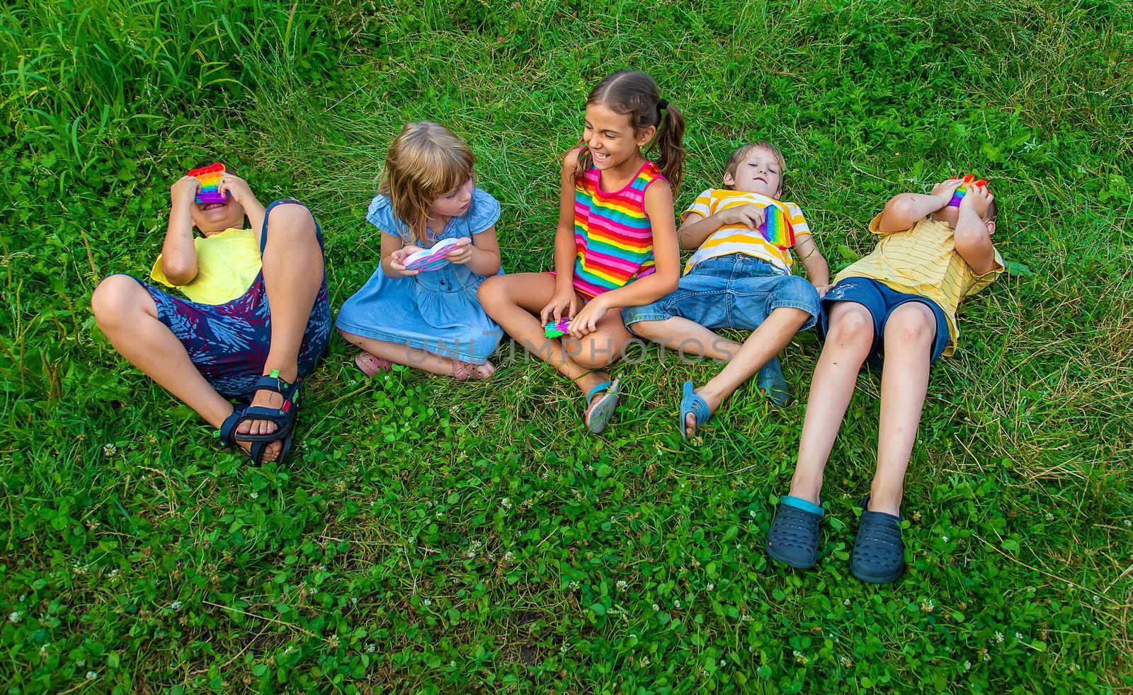 Children play anti-stress popit on the street. Selective focus. by yanadjana