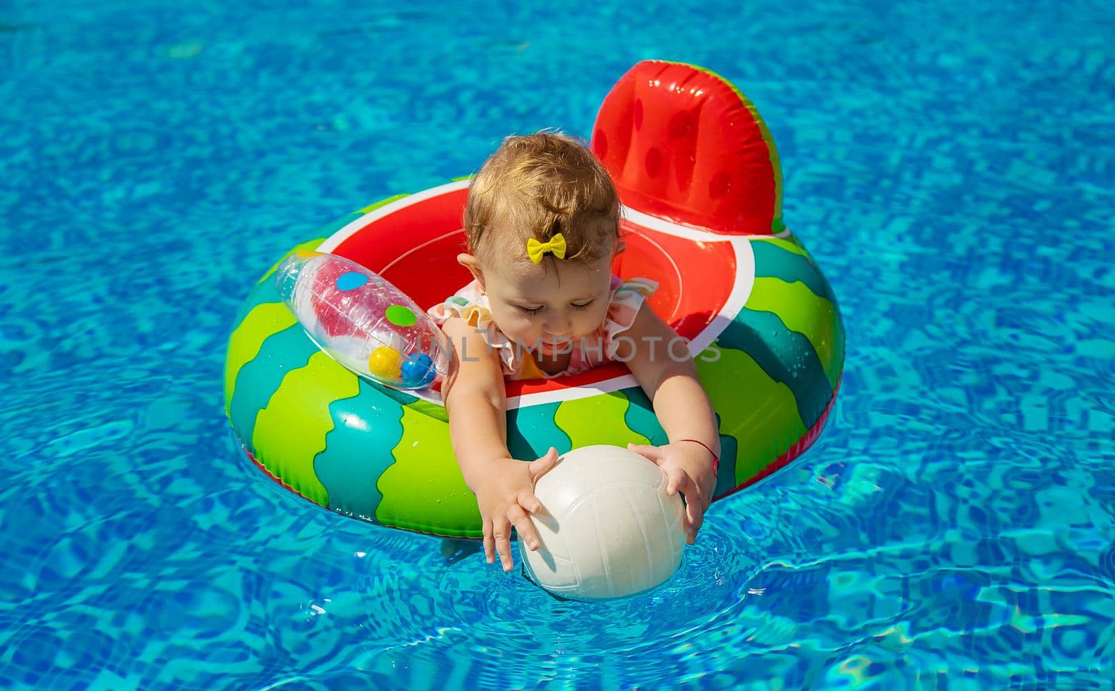 Baby swims in a circle in the pool. Selective focus. by yanadjana