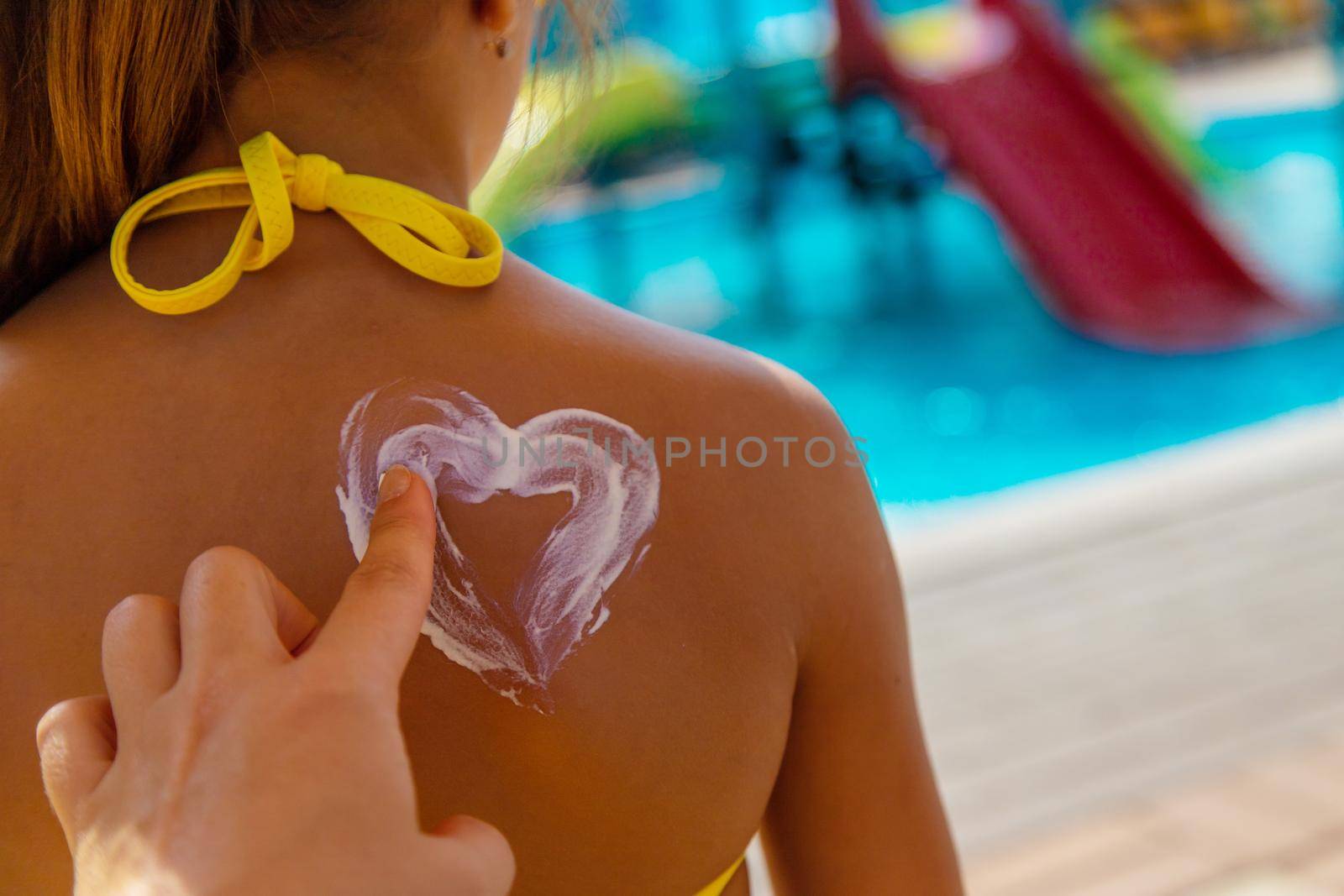 Sunscreen on the back of the child. Selective focus. Kid.