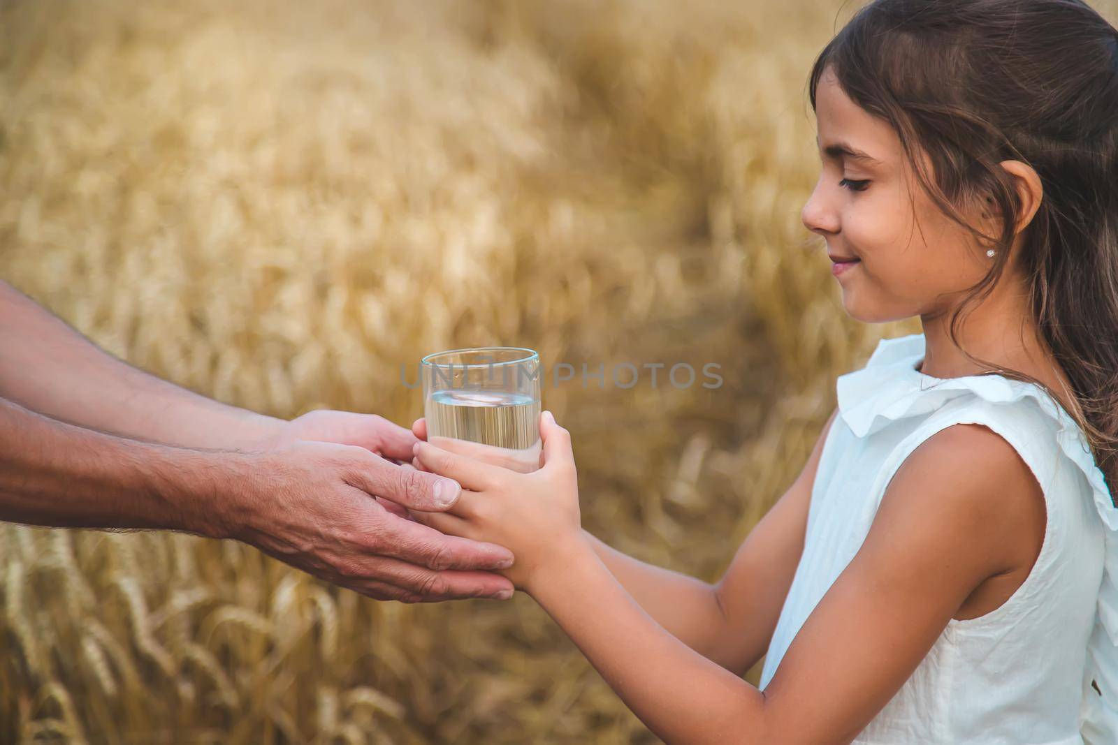 Father and child with a glass of water. Selective focus. Kid.