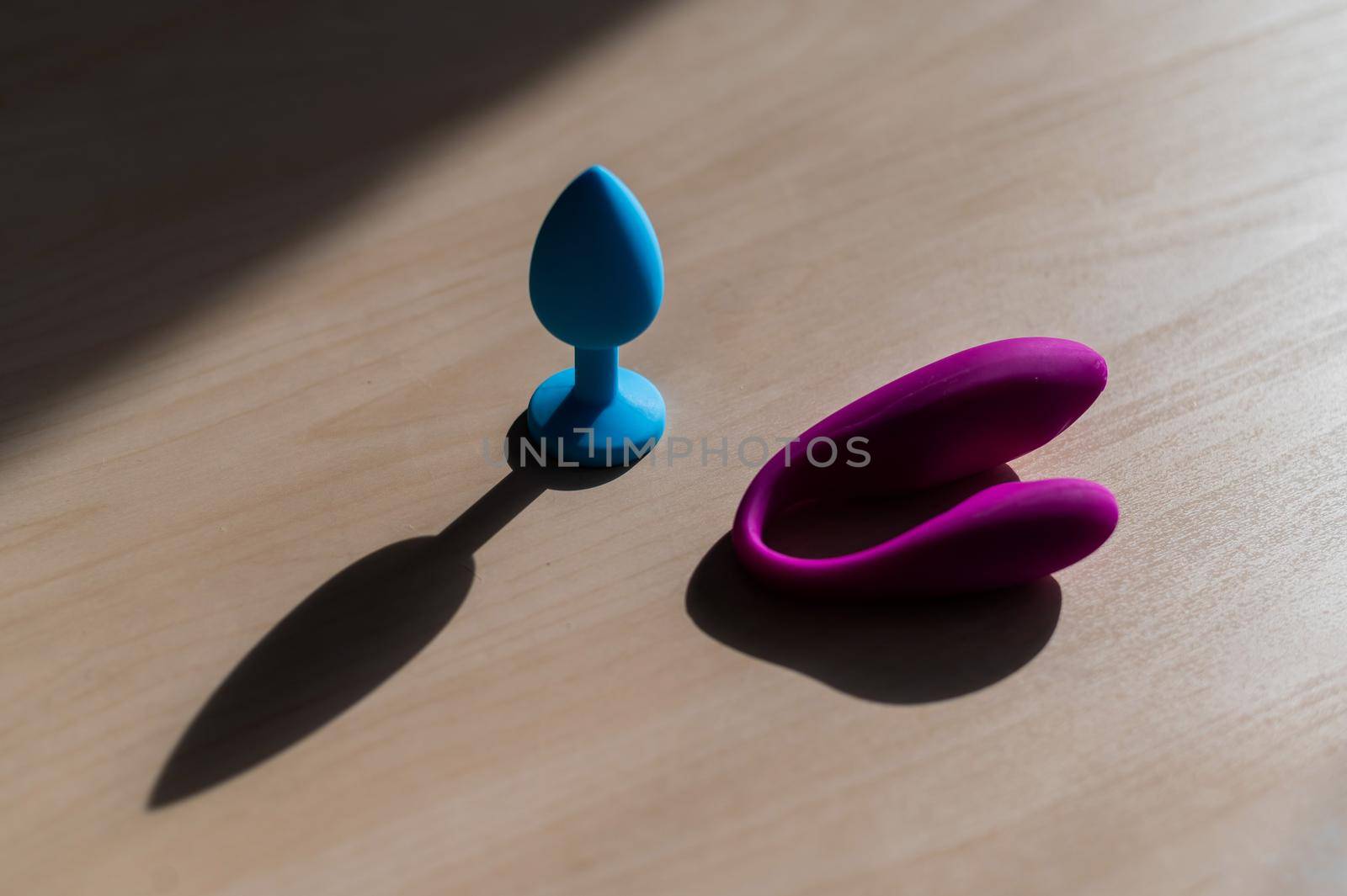 A set of sex toys from latex. Blue silicone butt plug and pink vaginal clitoral vibrator. Curved Massager Point G Stimulato