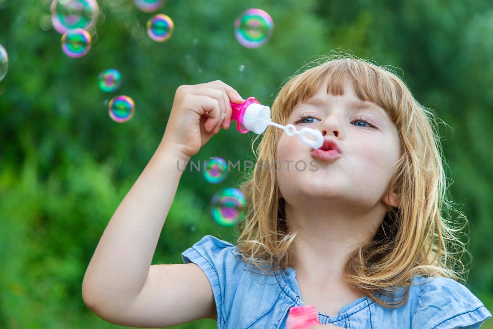 Children blow bubbles in the street. Selective focus. nature.