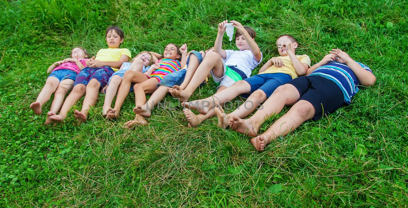 Children's feet lie on the grass. Selective focus. Kid.