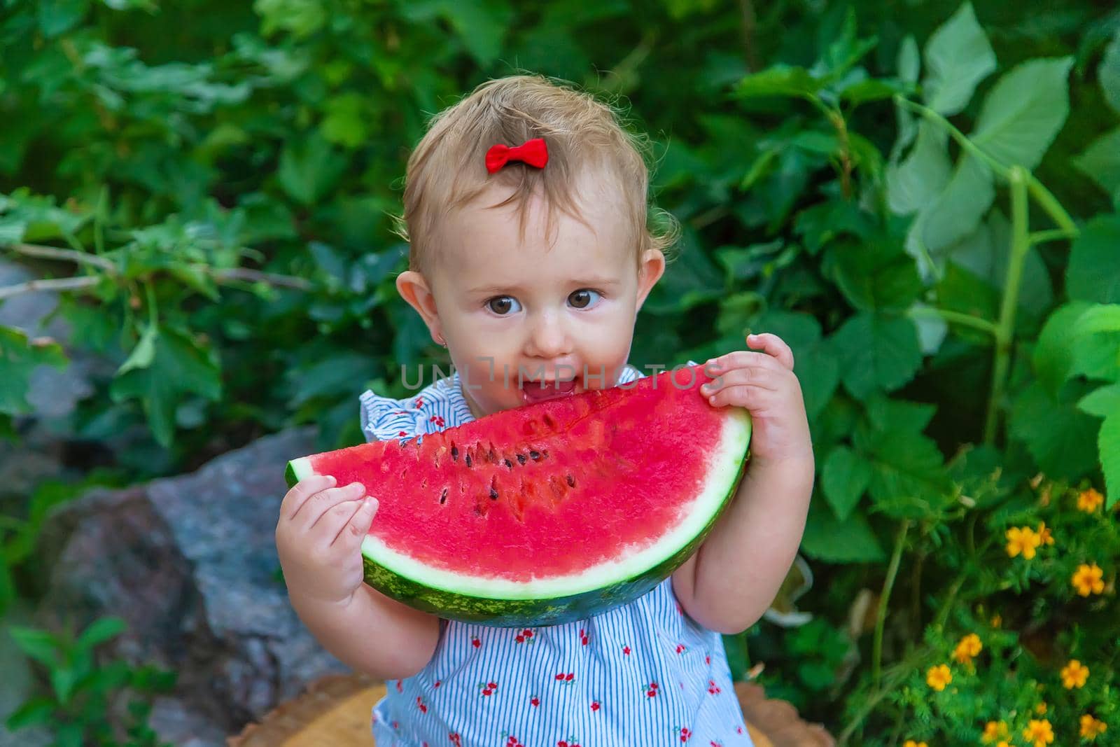 Baby eats watermelon in summer. Selective focus. Food.