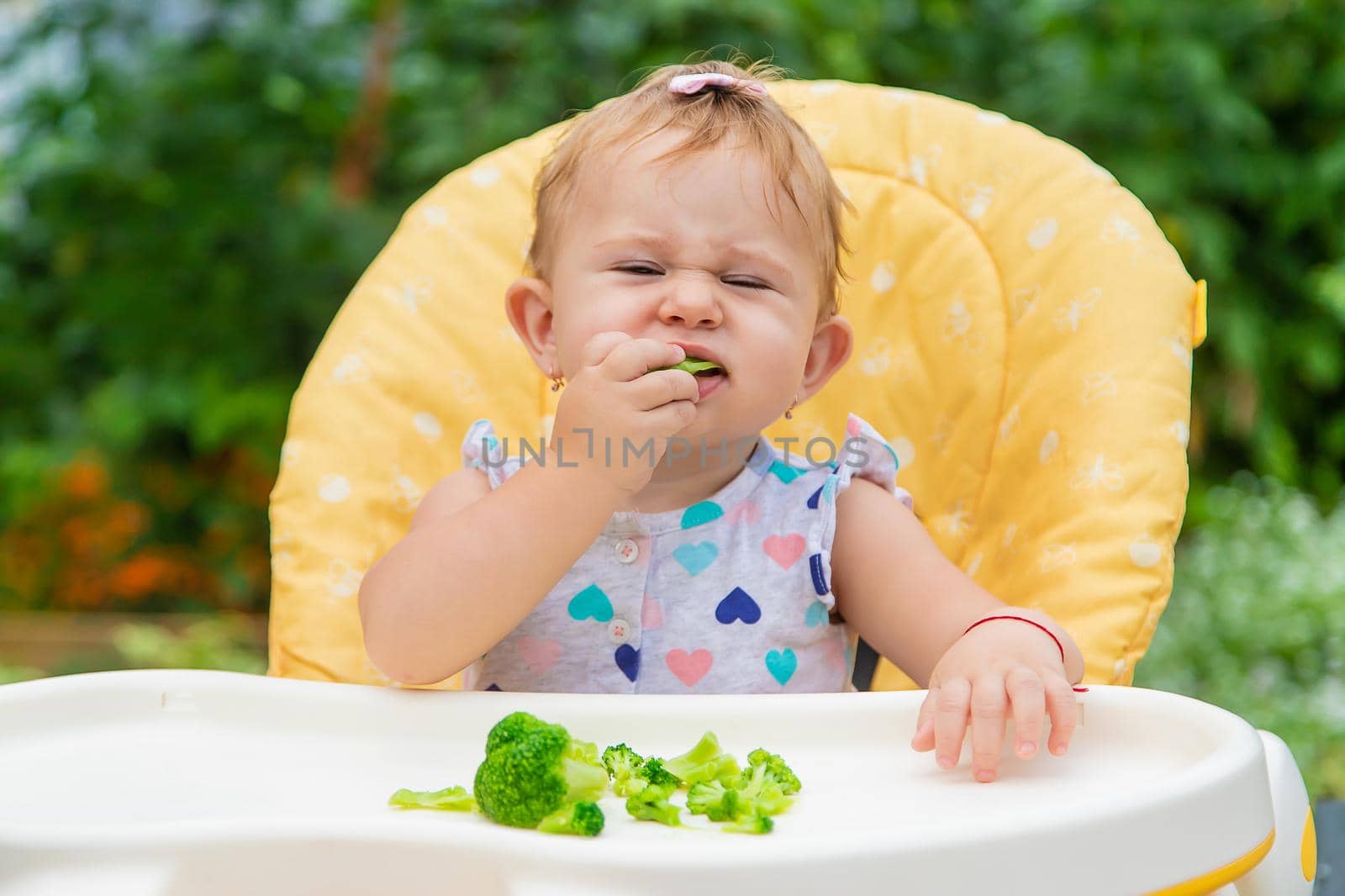 Baby eats pieces of broccoli vegetables. Selective focus. Child.