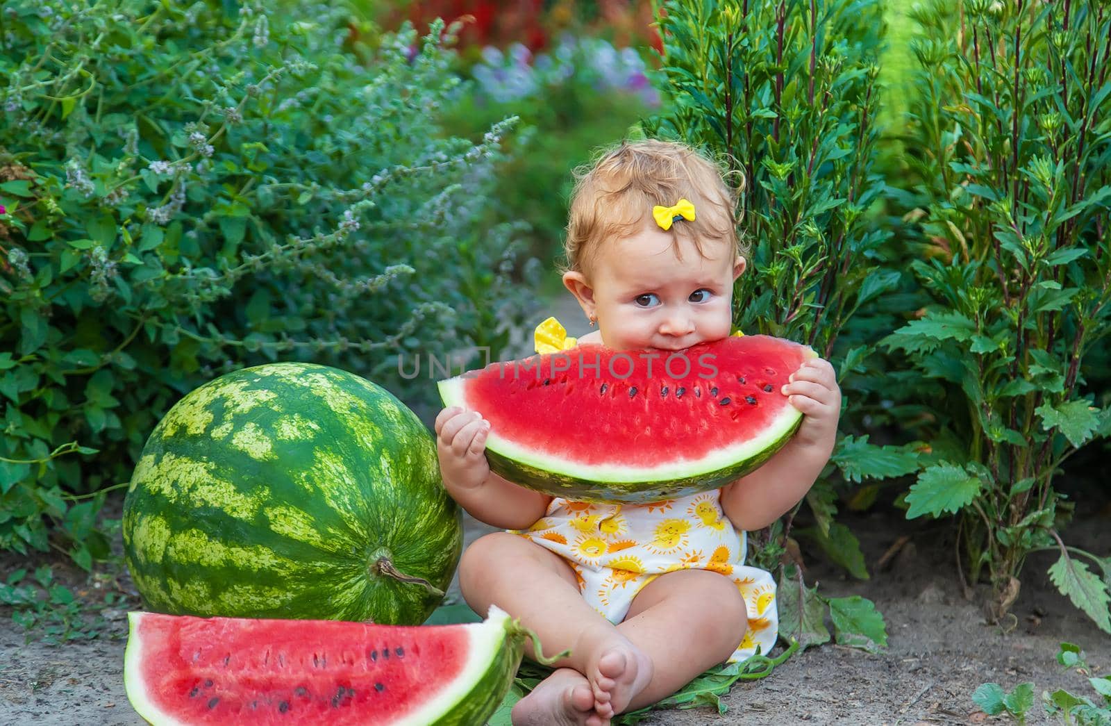 The child eats watermelon in the summer. Selective focus. Baby.