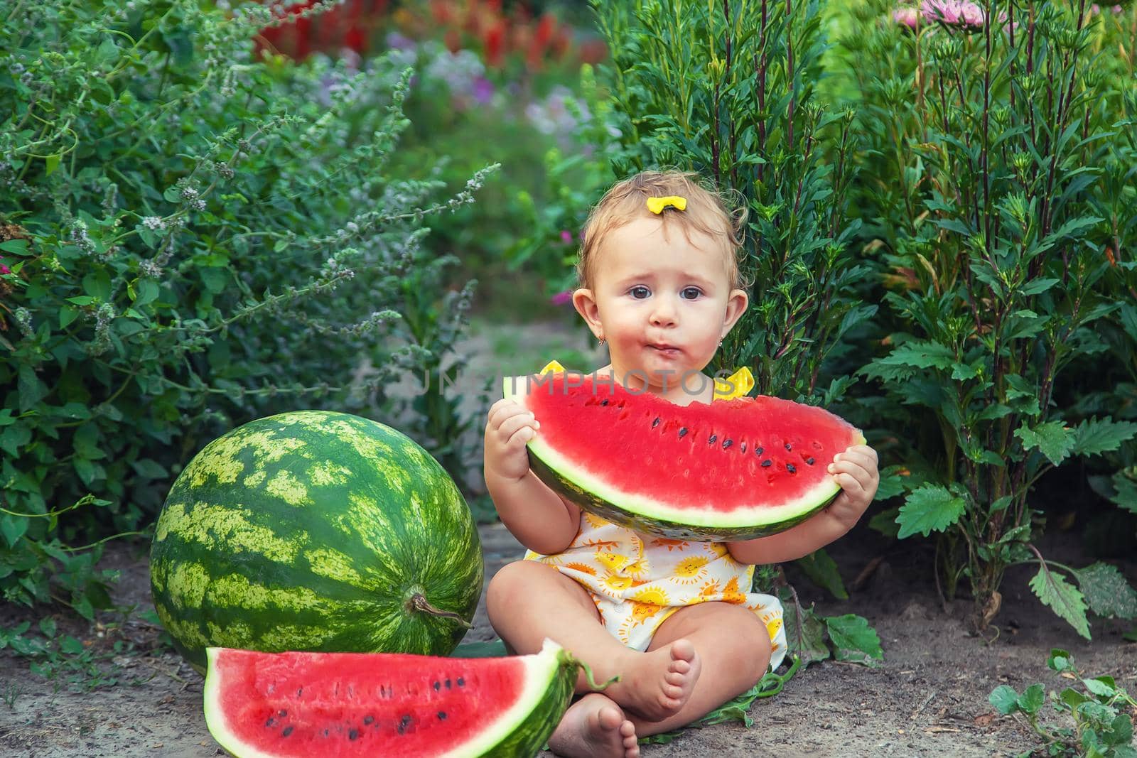 The child eats watermelon in the summer. Selective focus. Baby.
