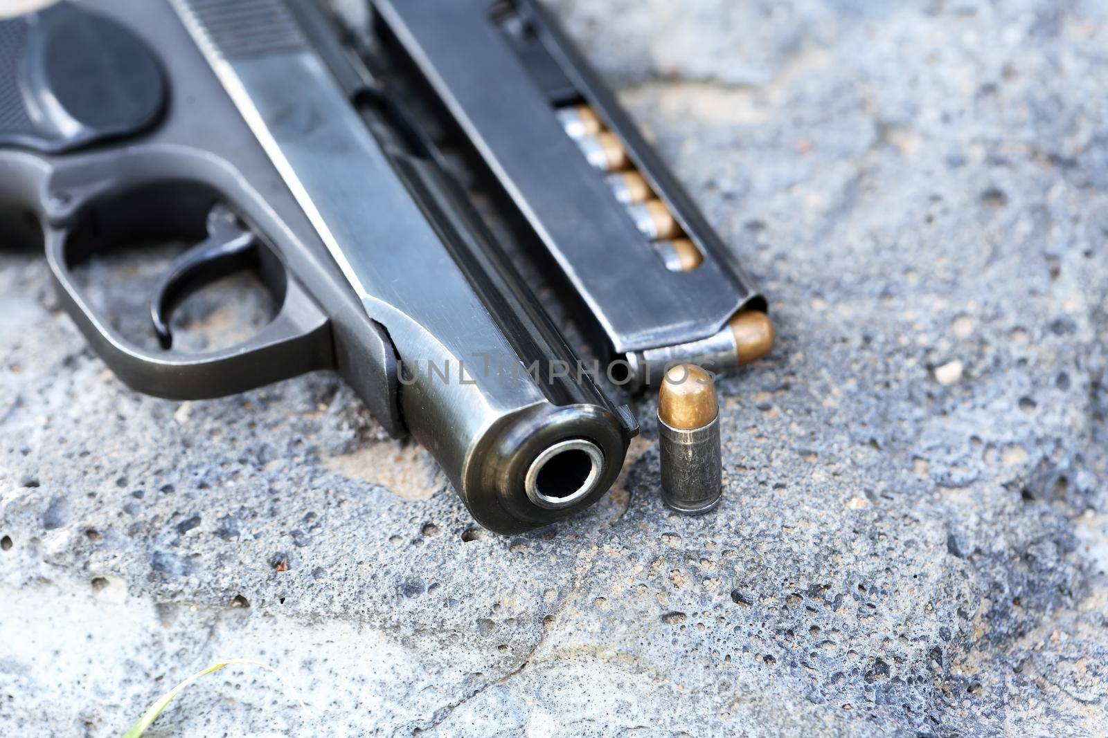 Eight-capacity magazine near handgun on gray stone background