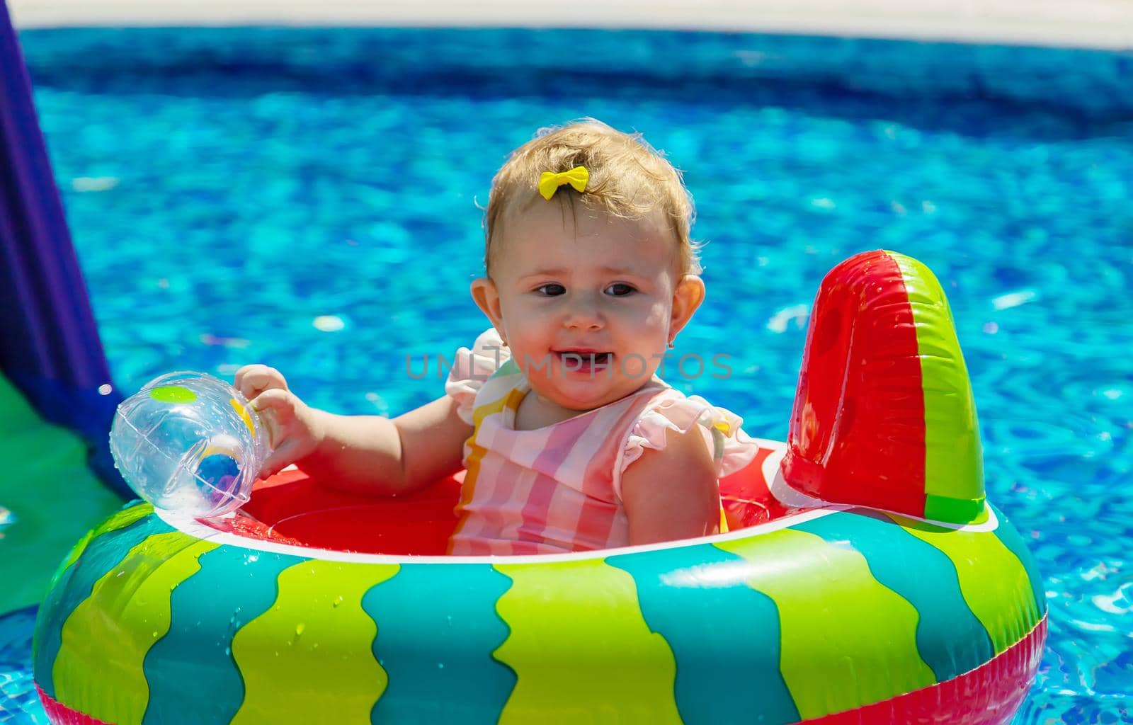 Baby swims in a circle in the pool. Selective focus. Child.