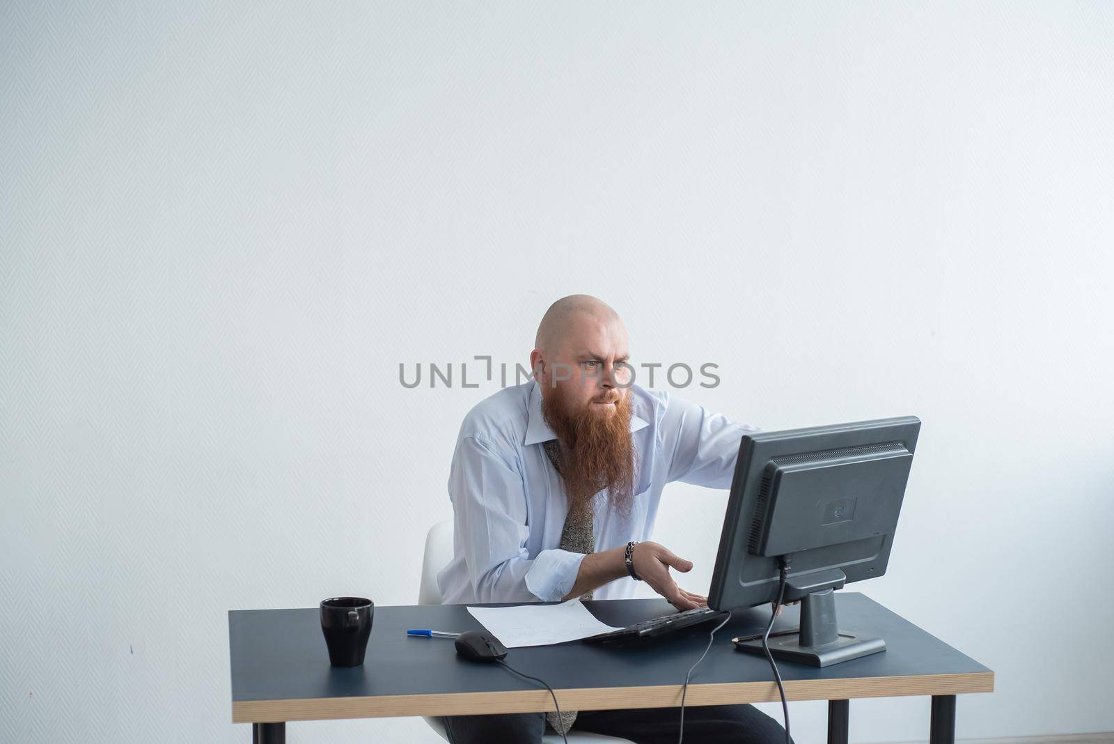 Problems for the office worker. A bald man in a white shirt sits at a desk with a computer and is stressed because of failure. A nervous breakdown. by mrwed54