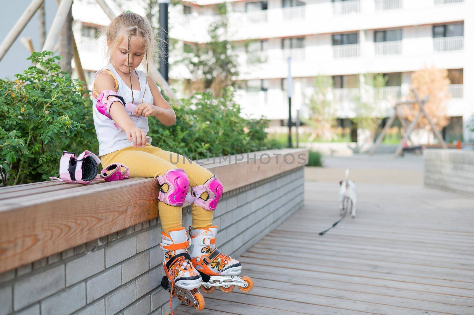 Little girl learns to roller skate outdoors