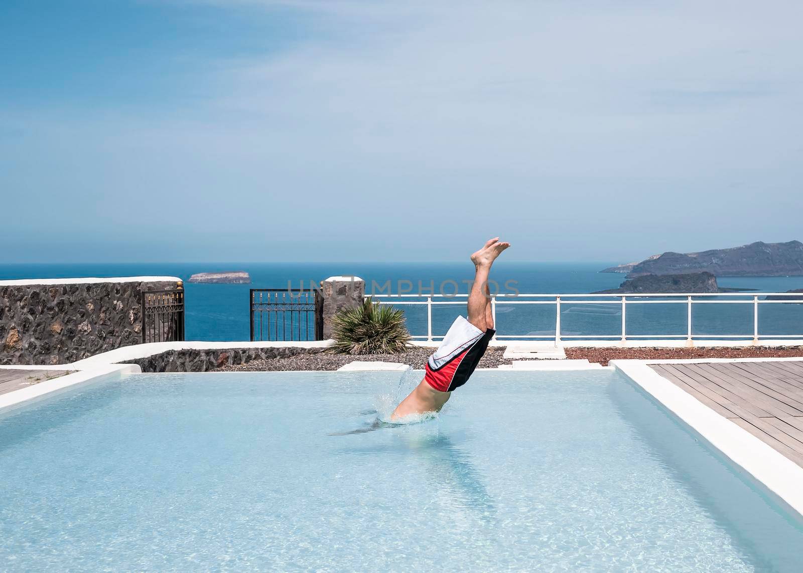 Man diving into a swimming pool in a villa.