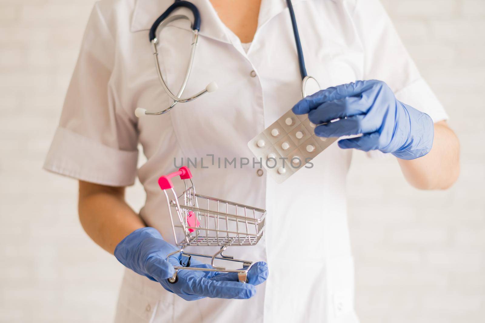 A faceless doctor puts a blister of pills in a mini shopping cart. by mrwed54