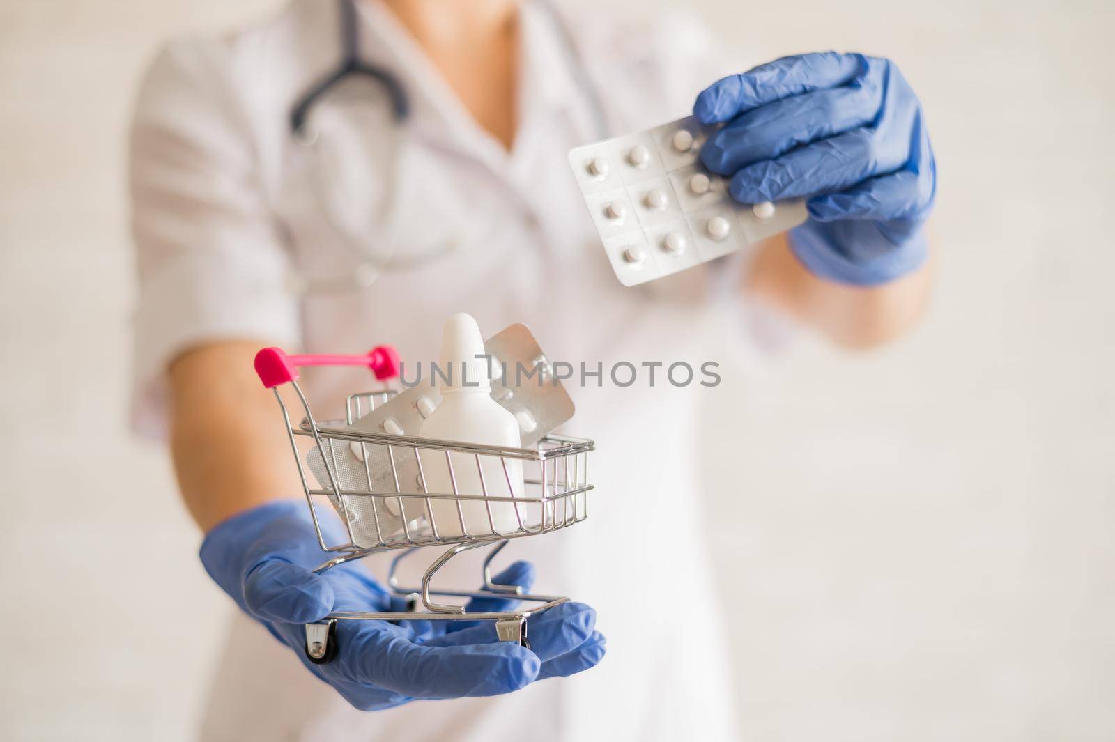 A faceless doctor puts a blister of pills in a mini shopping cart