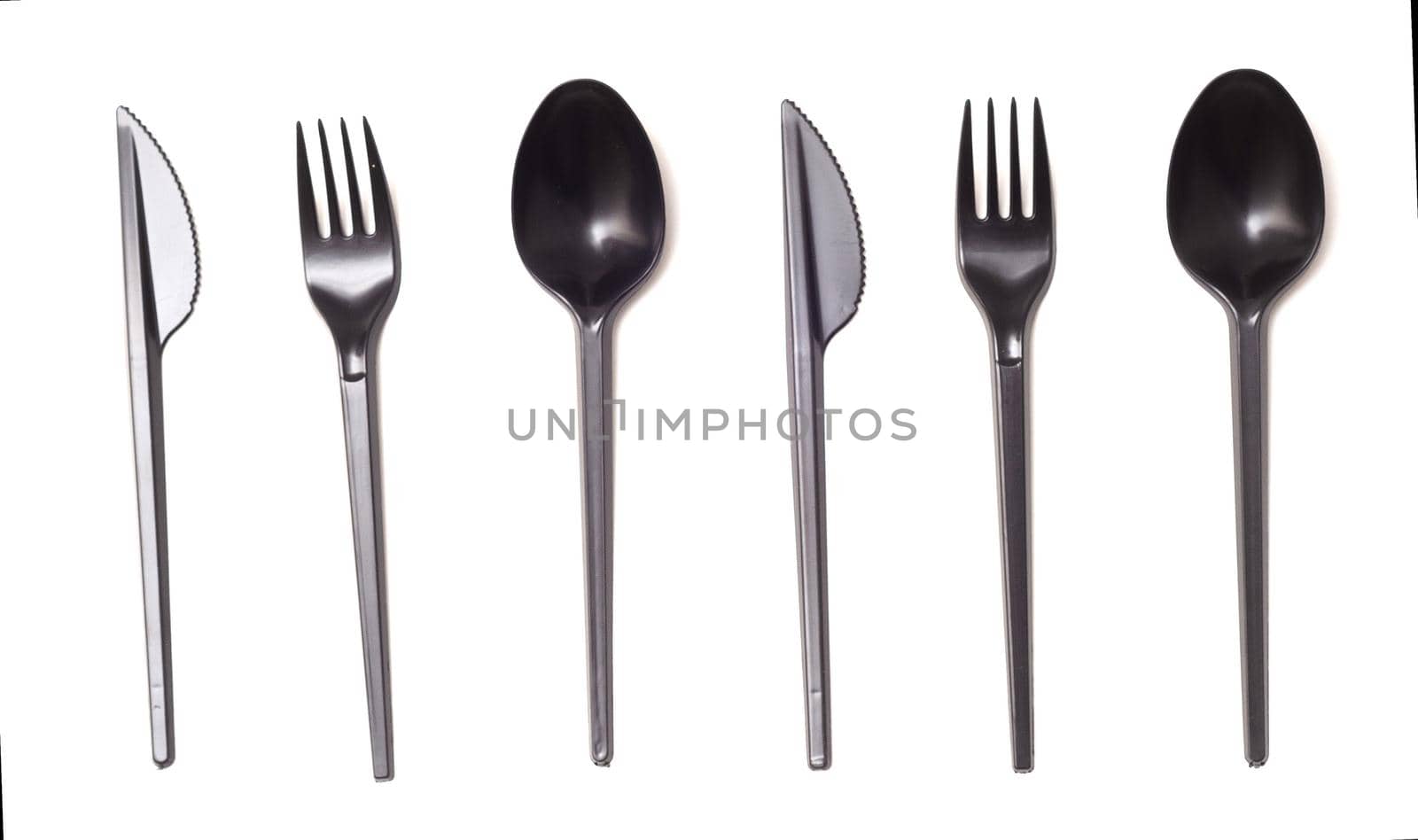 Repeating black plastic disposable knife,spoon and fork isolated on white, top view