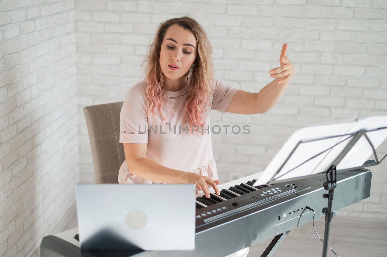 Remote music lessons. A singing teacher records the lesson on a laptop webcam