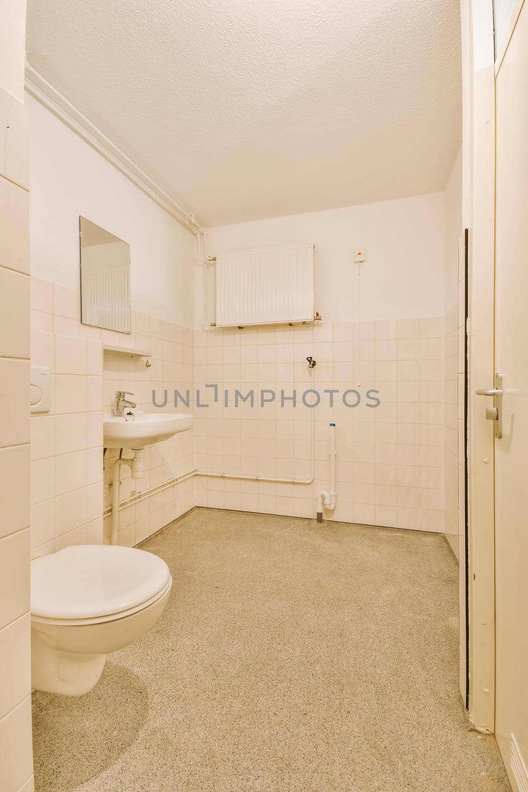 Modern flush toilet and ceramic sink installed on white tiled walls near mirror and towel in small restroom at home