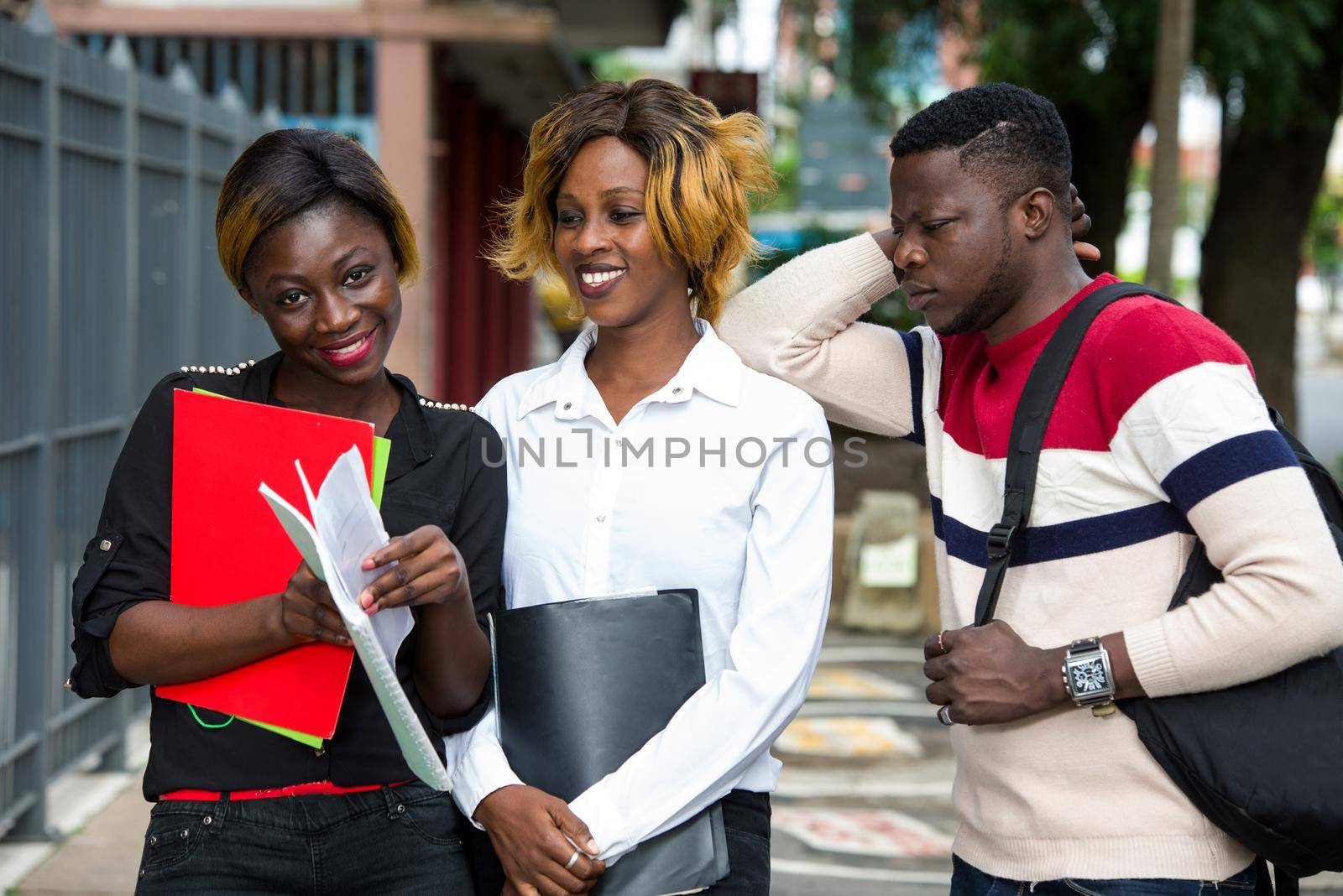group of students standing outside after class with notebook smiling.
