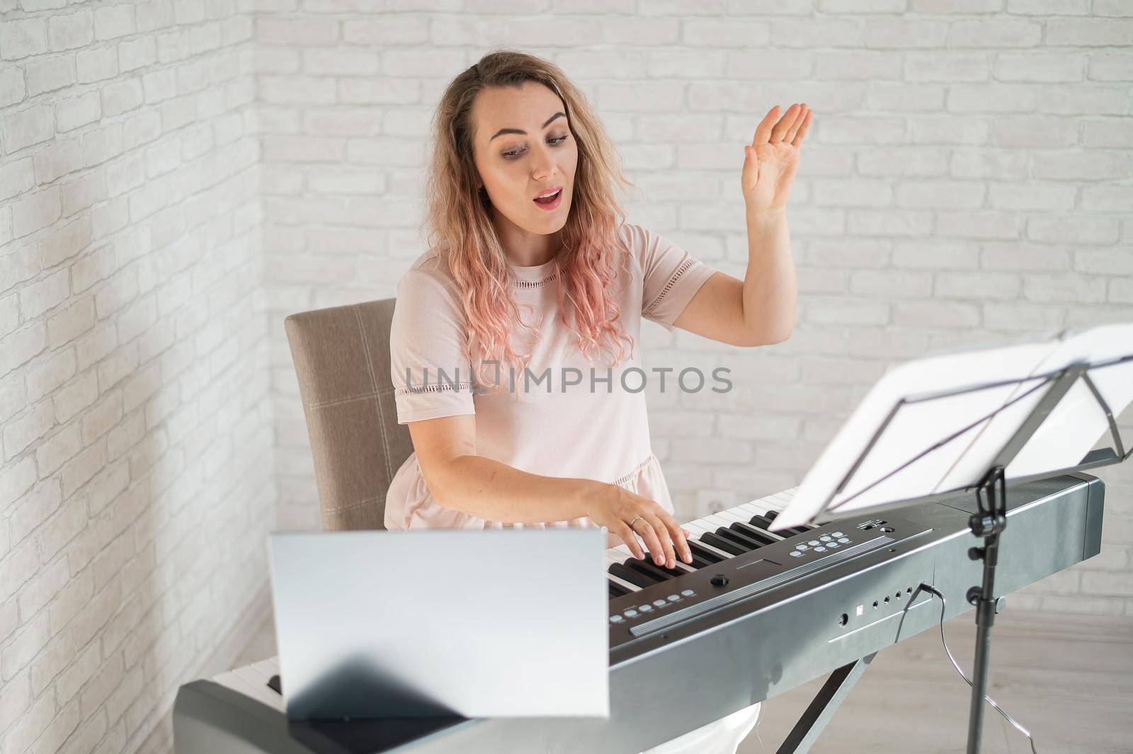 Remote music lessons. A singing teacher records the lesson on a laptop webcam