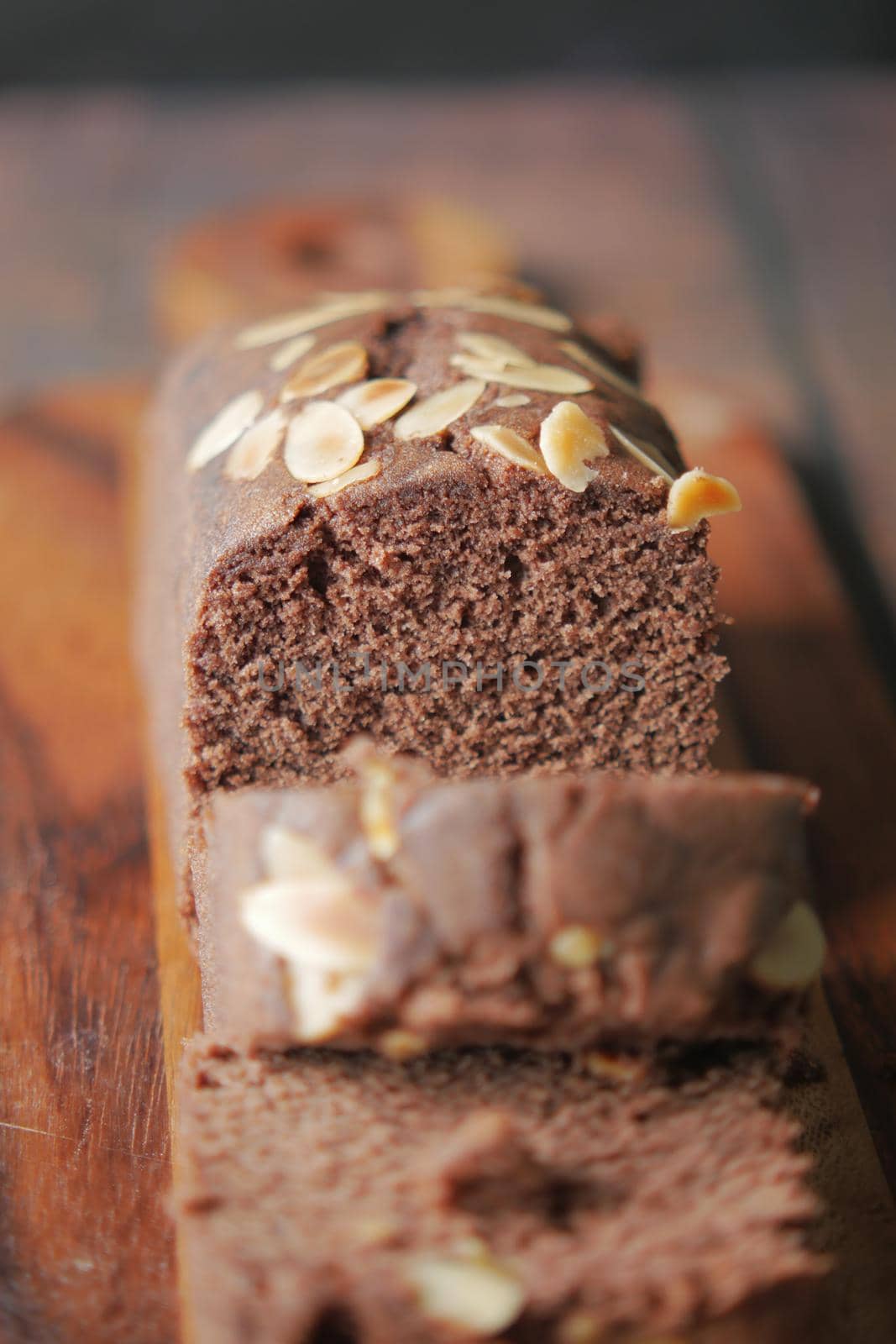 slice of bakery chocolate cake on chopping board.