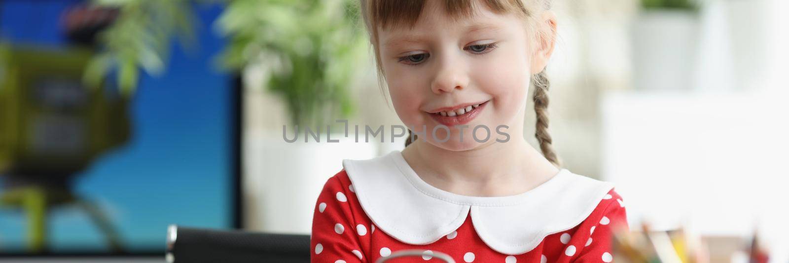 Little girl learning how to understand time and playing with red vintage clock by kuprevich