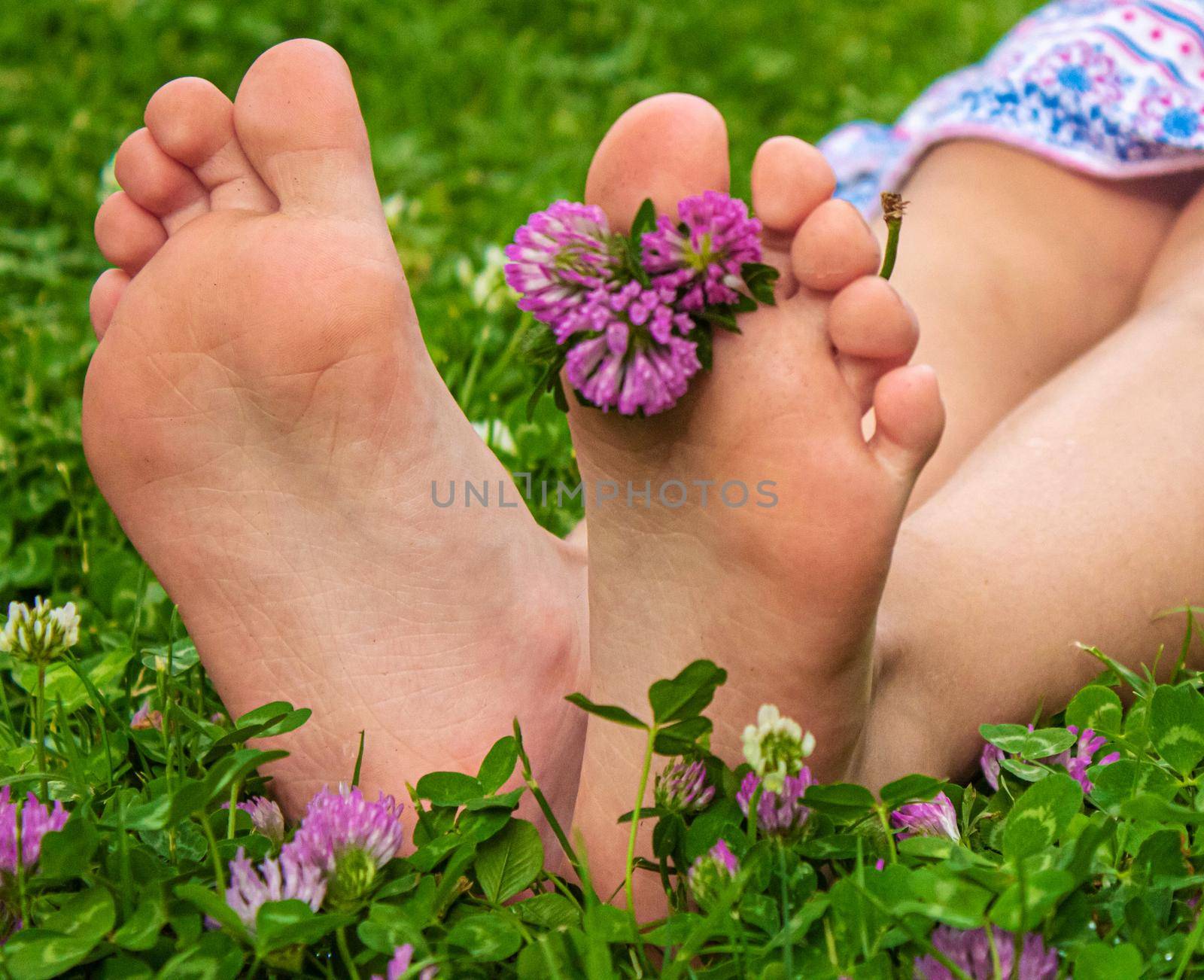 Children's feet with a pattern of paints smile on the green grass. Selective focus. nature.