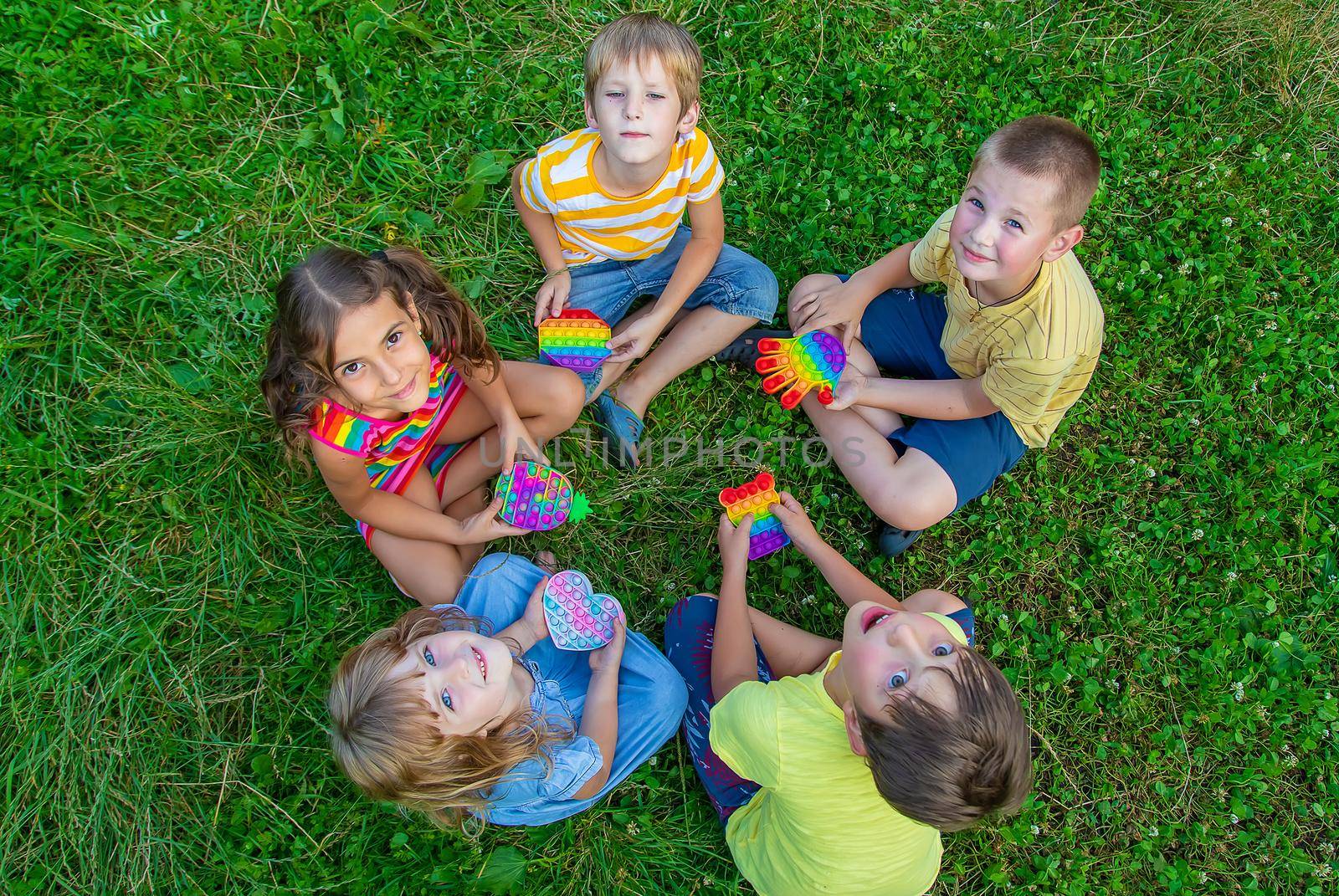 Children play anti-stress popit on the street. Selective focus. Kids.