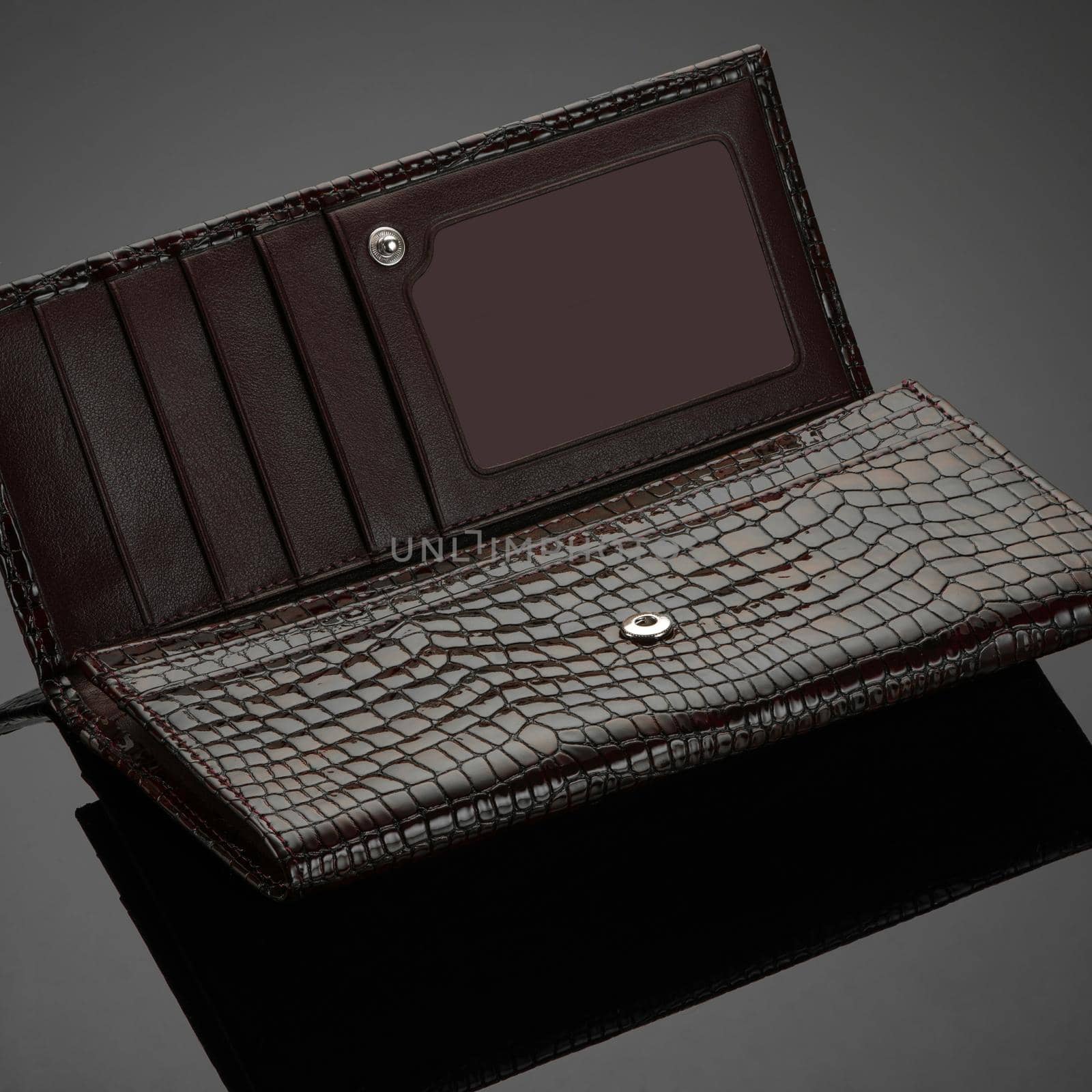 A closeup of a fashionable leather wallet on a dark background