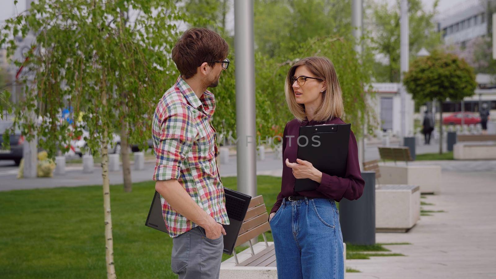 Two college students meeting and talking on campus, in a park. Exam period.Having serious conversation