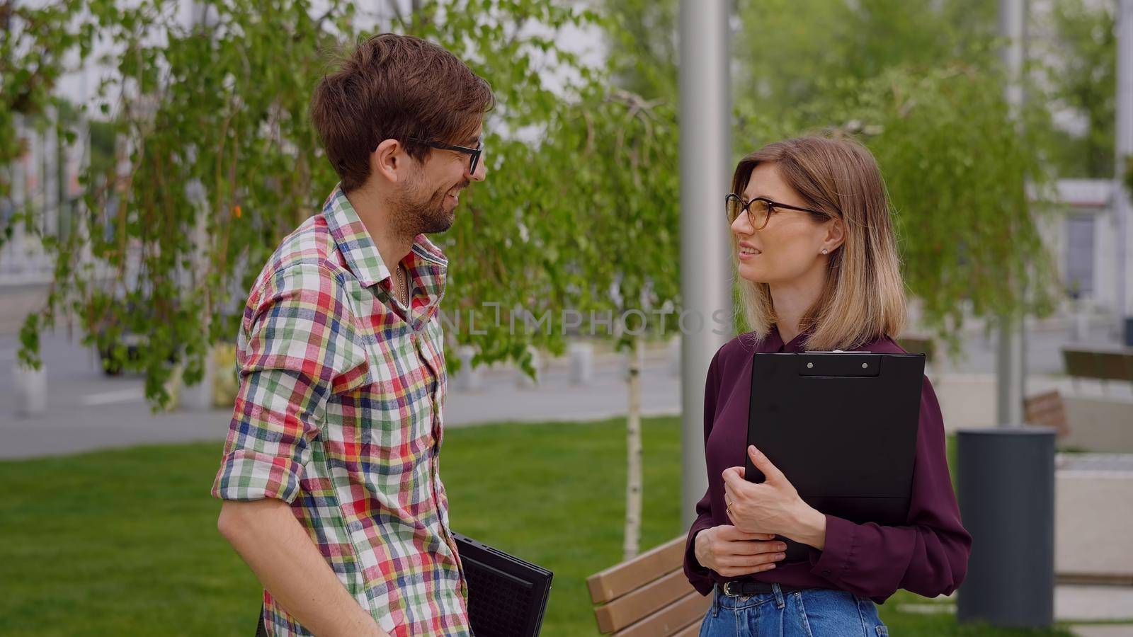 Two college students meeting and talking on campus, in a park. Exam period.Having serious conversation