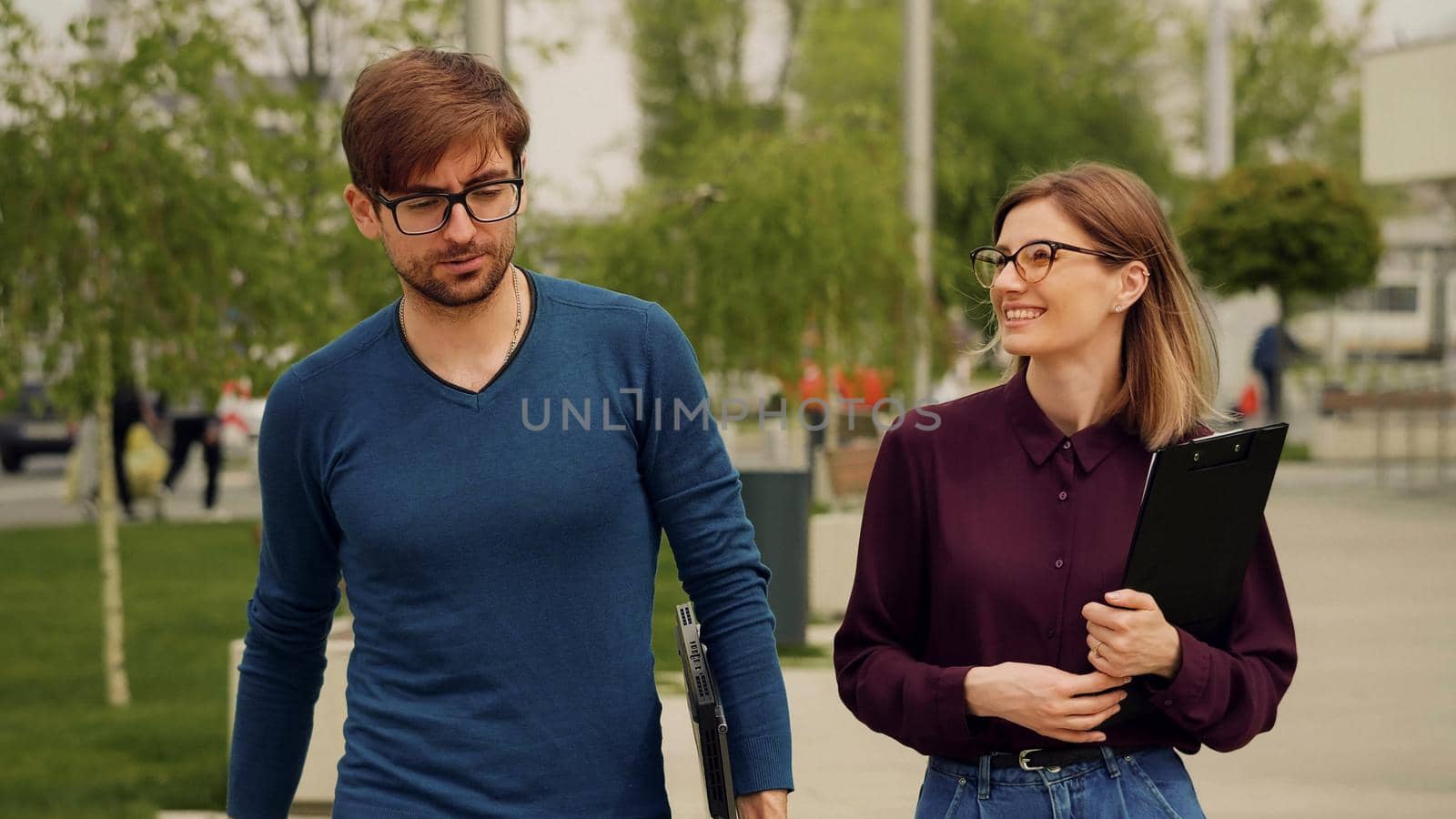 Business people walking together out of office building and discussing succesful business project. by RecCameraStock