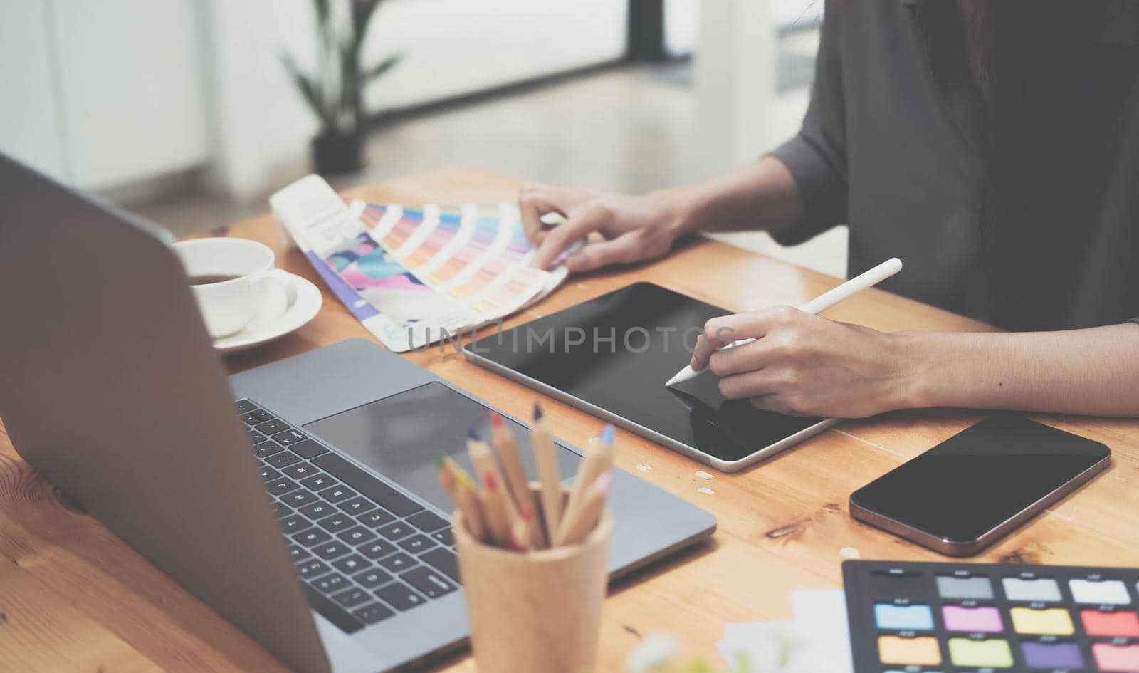 Young photographer and graphic designer at work in office. Blank screen monitor for graphic display montage..