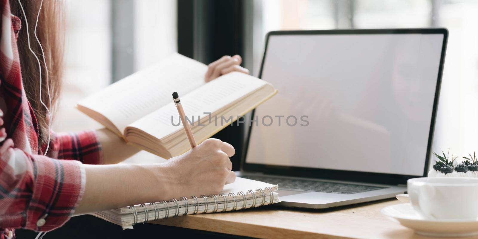 Cropped image Young female freelancer blogger influencer writing notes on her diary by wichayada
