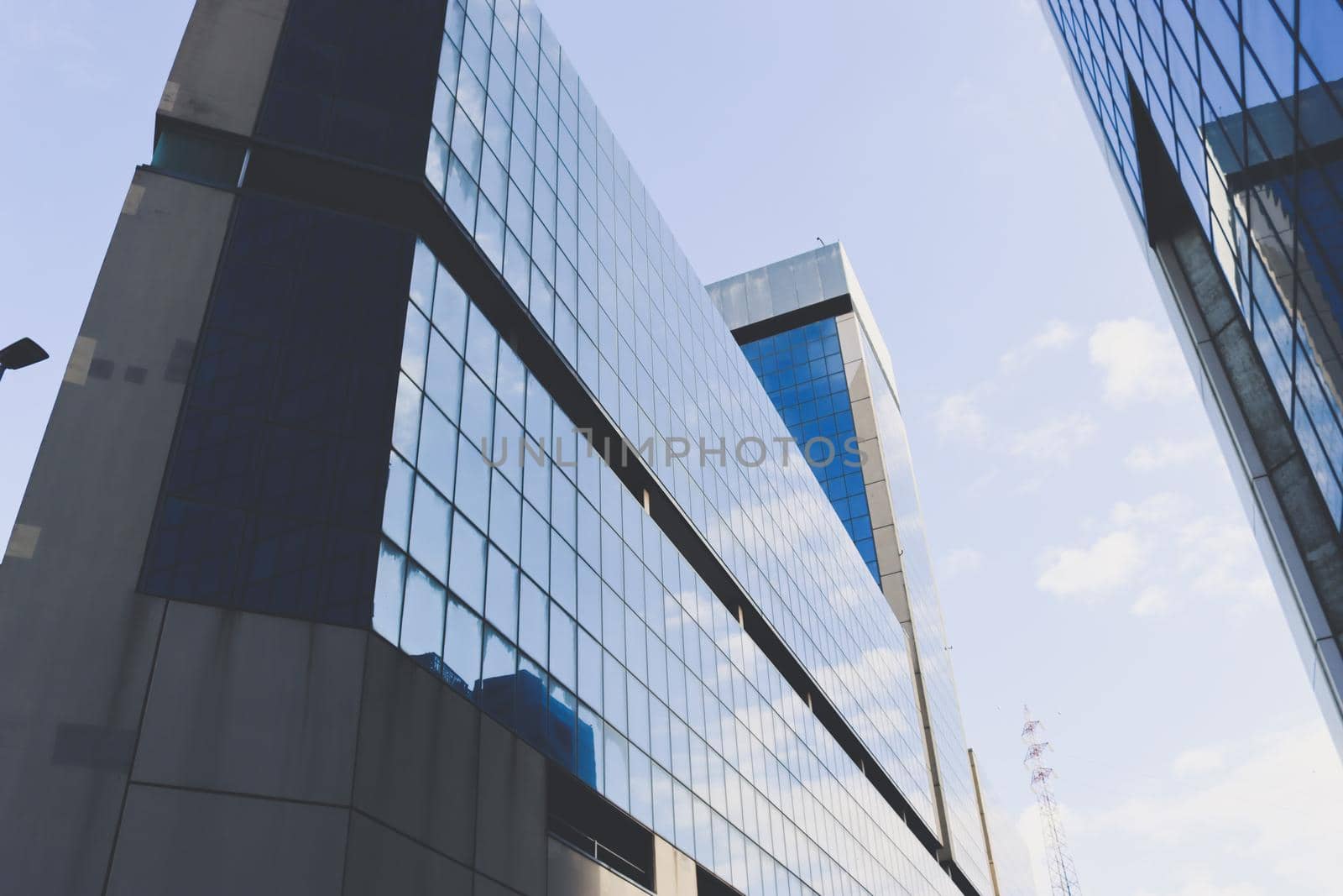 Genova, Italy-January 29, 2022: Beautiful modern high-rise buildings against the sky. 3d illustration on the theme of business success and technology. clouds reflection on the mirror.Industrial zone.