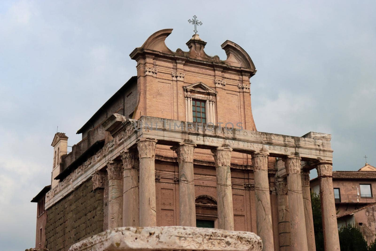 ROME, ITALY - February 05, 2022: Panoramic view around the Colosseum in city of Rome, Italy. Cold and gray sky in the background. Macro photography of the green parks with the old buildings.