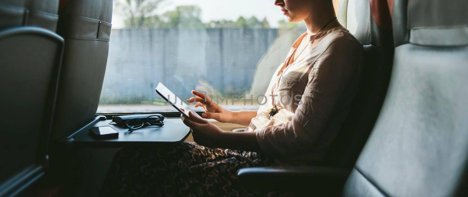 Woman traveling by train using mobile phone