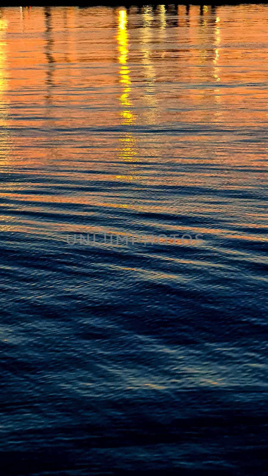 Genova, Italy- June 20,2022: Port of Porto Antico harbor with luxury yachts and attractions, Bigo construction in historical centre of old european city Genoa with beautiful sunset reflection.