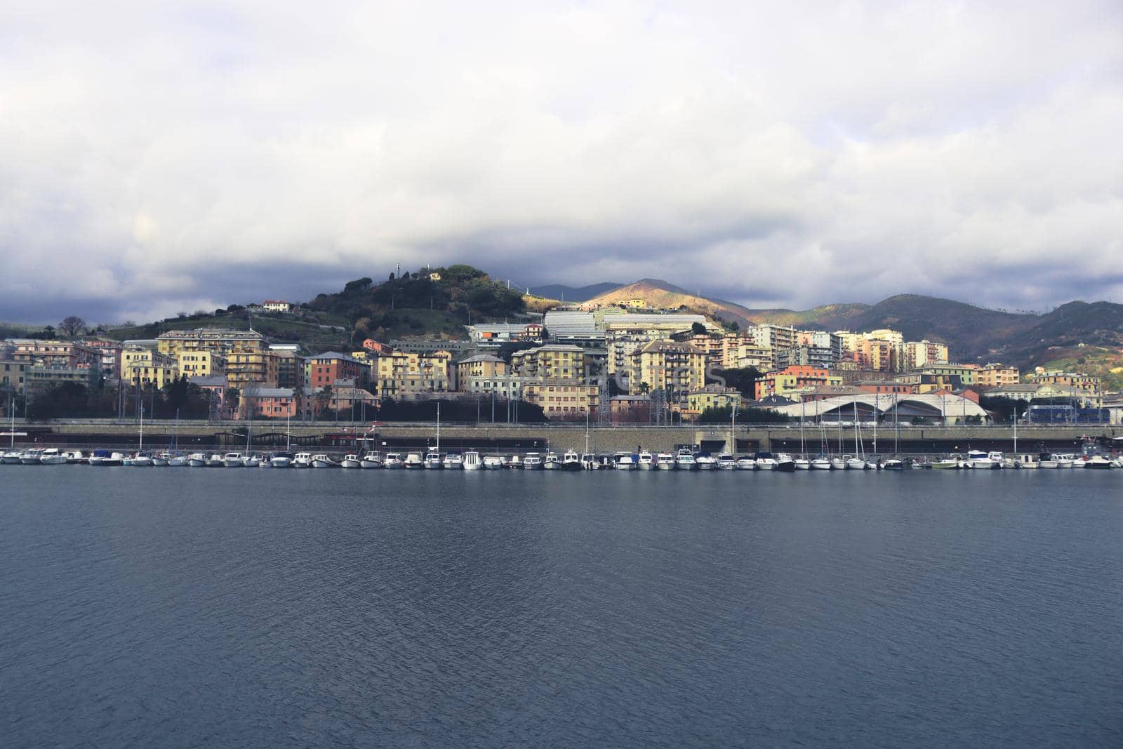 Genova, Italy- June 20,2022: Port of Porto Antico harbor with luxury yachts and attractions, Bigo construction in historical centre of old european city Genoa with beautiful sunset reflection.