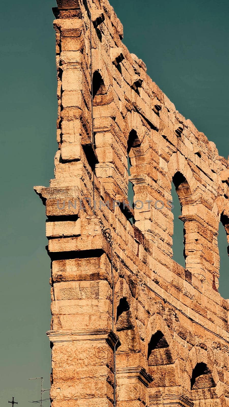 ROME, ITALY - February 05, 2022: Panoramic view around the Colosseum in city of Rome, Italy. Cold and gray sky in the background. Macro photography of the green parks with the old buildings.