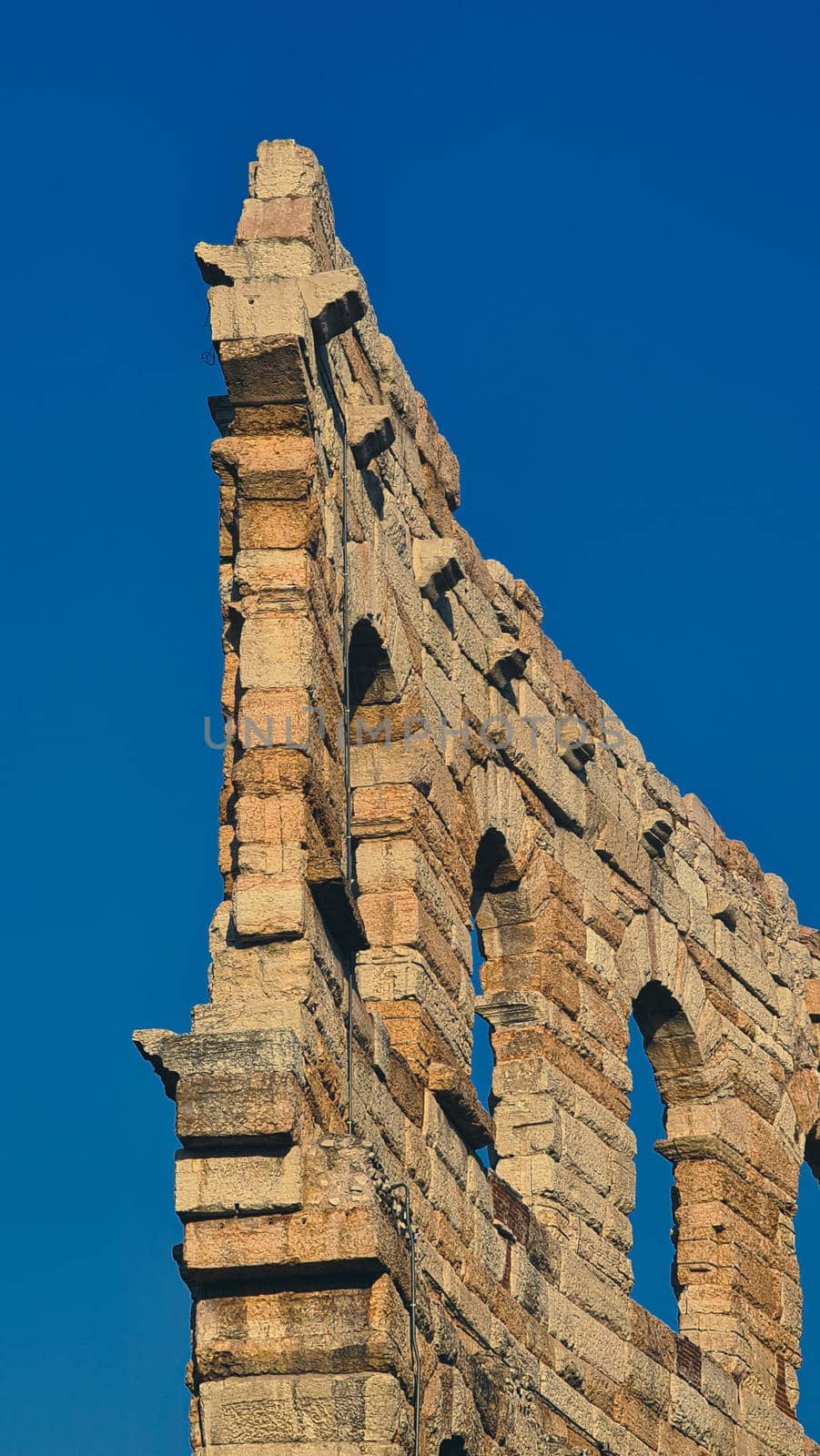 ROME, ITALY - February 05, 2022: Panoramic view around the Colosseum in city of Rome, Italy. Cold and gray sky in the background. Macro photography of the green parks with the old buildings.